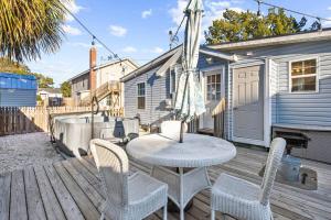 a patio with a table and chairs on a deck at Beautiful Centrally Located Beach House w King Bed, Private Hot tub, Yard, Deck & BBQ in Myrtle Beach