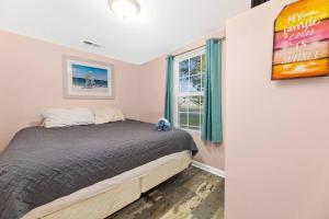 a bedroom with a bed and a window at Beautiful Centrally Located Beach House w King Bed, Private Hot tub, Yard, Deck & BBQ in Myrtle Beach