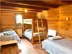um quarto com 2 beliches num chalé de madeira em The Barn at Evermore: riverfront retreat w/hot tub em Luray