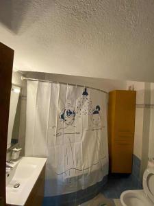 a bathroom with a toilet and a shower curtain at Dellmar Apartment in Perea