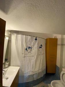 a bathroom with a toilet and a shower curtain at Dellmar Apartment in Perea +41 photos