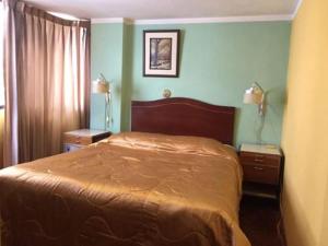 a bedroom with a large bed and two night stands at Puno Wasi Hotel in Puno