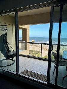 a room with a view of the ocean from a balcony at Absolute Beachfront at the Pier Glenelg in Glenelg