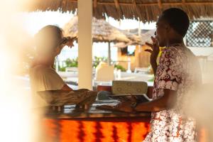 two women standing in front of a table at Kupaga Villas Boutique Hotel - Adults Only in Jambiani