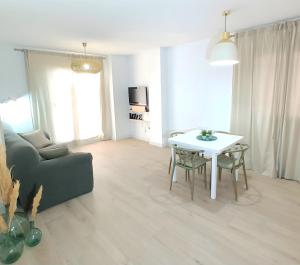 a living room with a couch and a table at Apartamento con terraza y acceso directo a piscina in Denia