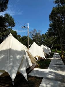 a row of white tents lined up in a row at Touching Camping in Hou-lung-tzu