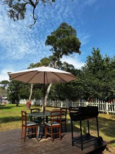a table and chairs with an umbrella and a grill at Touching Camping in Hou-lung-tzu