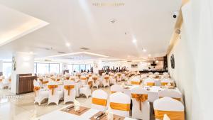 un salón de banquetes con mesas y sillas blancas en YEN BIEN LUXURY HOTEL, en Ha Giang