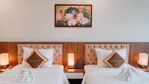 two beds in a hotel room with a picture on the wall at YEN BIEN LUXURY HOTEL in Ha Giang +43 photos
