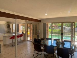 a kitchen and dining room with a glass table and chairs at Waterfront Luxury 4 bed Home walking to Broadwater in Gold Coast