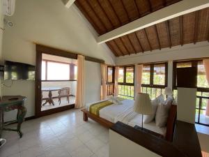 勒吉安Three Brothers Bungalows & Villas的一间带床的卧室和一个带桌子的阳台