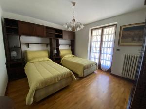 een slaapkamer met 2 bedden en een groot raam bij Baita pressi Gran Paradiso in Sparone