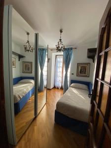 een slaapkamer met 2 bedden en een spiegel bij Baita pressi Gran Paradiso in Sparone
