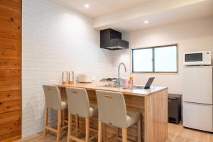 una cucina con bancone in legno ed elettrodomestici bianchi di The Lodge Yamanakako by nestate つつじ a Yamanakako