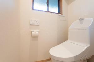 un bagno con servizi igienici bianchi e finestra di The Lodge Yamanakako by nestate つつじ a Yamanakako Altre 28 foto