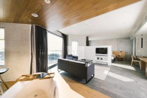 a living room with a couch and a television at Nest Hotel Incheon in Incheon