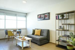 ein Wohnzimmer mit einem Sofa und einem Tisch in der Unterkunft Simple Living in Netanya Center by Sea N' Rent in Netanya