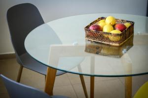 ein Obstkorb auf einem Glastisch in der Unterkunft Simple Living in Netanya Center by Sea N' Rent in Netanya