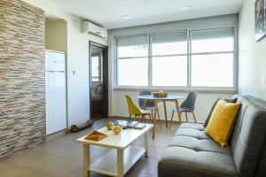 ein Wohnzimmer mit einem Sofa und einem Tisch in der Unterkunft Simple Living in Netanya Center by Sea N' Rent in Netanya