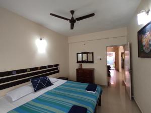 a bedroom with a bed and a ceiling fan at Beach Apartment 2,COLVA , GOA, INDIA in Colva