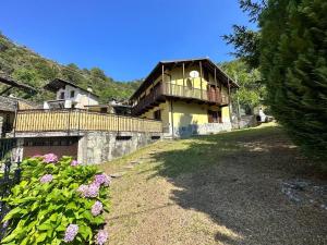 a large building with a balcony and some flowers at Baita pressi Gran Paradiso in Sparone