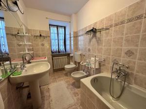 a bathroom with a sink and a tub and a toilet at Baita pressi Gran Paradiso in Sparone