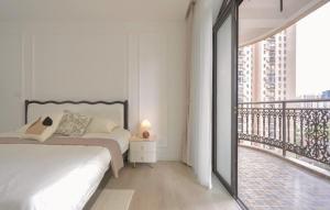 a white bedroom with a bed and a balcony at Sun Wonderland Apartment - Near The Bund in Shanghai