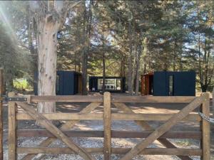 una recinzione di legno di fronte ad un albero di Bosque a Necochea