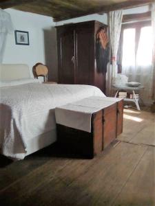 um quarto com uma cama grande e uma cadeira em A s'antiga em Seùlo