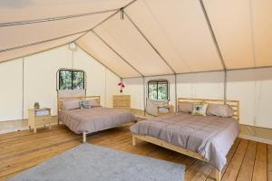 a bedroom with two beds in a tent at Twin Falls Luxury Glamping - Cozy Retreat in Boerne