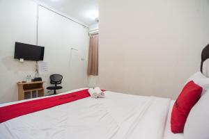 a bedroom with a bed with a teddy bear on it at RedDoorz Plus near RS PMI Bogor in Bogor