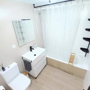 a bathroom with a white sink and a toilet at Apartamento con terraza y acceso directo a piscina in Denia