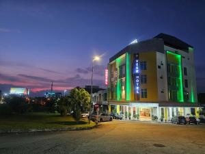 a building with neon signs on it at night at Veer Hotel in Kuantan