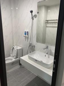 une salle de bain blanche avec toilettes et lavabo dans l'établissement Minh Quân Hotel HN - by BAY LUXURY, à Thượng Thôn