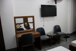 une chambre avec un miroir, deux chaises et une table dans l'établissement Minh Quân Hotel HN - by BAY LUXURY, à Thượng Thôn