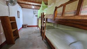 a room with two bunk beds in a room at Monkey House Hostel in Tola