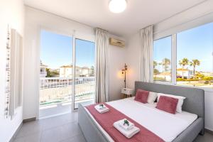 a bedroom with a large bed with a large window at Ayia Thekla Seafront Villa Dagi in Ayia Napa