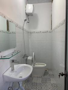 La salle de bains est pourvue d'un lavabo et de toilettes. dans l'établissement Rừng Phố Homestay And Coffee, à Kon Plong