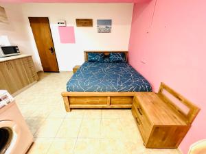 a bedroom with a bed in a pink wall at КВАРТИРА ВОЗЛЕ БАХАЙСКИХ САДОВ! in Haifa