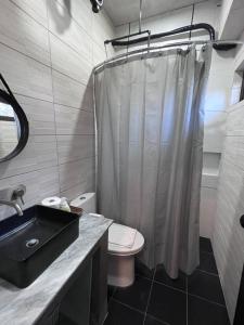 a bathroom with a shower curtain and a toilet at Brisa de Cristal at Canyon Cove Nasugbu Batangas in Nasugbu