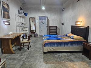 a bedroom with a bed and a table and a desk at Bali Bobo Hostel in Jimbaran