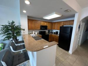 eine Küche mit einer Theke und einem schwarzen Kühlschrank in der Unterkunft Huge Pool, Sunrise Lakeview 12th floor near Disney in Orlando