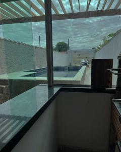 een raam in een kamer met uitzicht op een zwembad bij Espaço praia boraceia in Bertioga
