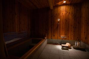 Habitación de madera con bañera y silla. en 草木ももとせ 