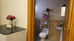 a bathroom with a toilet and a vase of flowers at شقة كبيرة عائلية VIP حي الوادي in Riyadh
