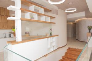 una cocina con paredes blancas y estanterías de madera en Casa Gaia, en Pescara