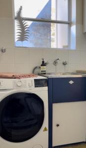 a kitchen with a washing machine and a window at Banyan, 14 Montevideo Parade - spacious pet friendly property with air con and free WiFi in Nelson Bay