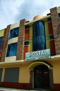 un bâtiment hospitalier avec un panneau devant lui dans l'établissement Hostal Casa del Valle, 