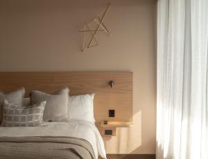 a bedroom with a large bed with a wooden headboard at Hotel Marvell Byron Bay in Byron Bay