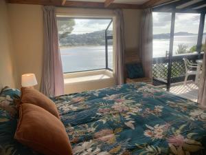 a bedroom with a bed and a view of the water at The Retreat in Paihia